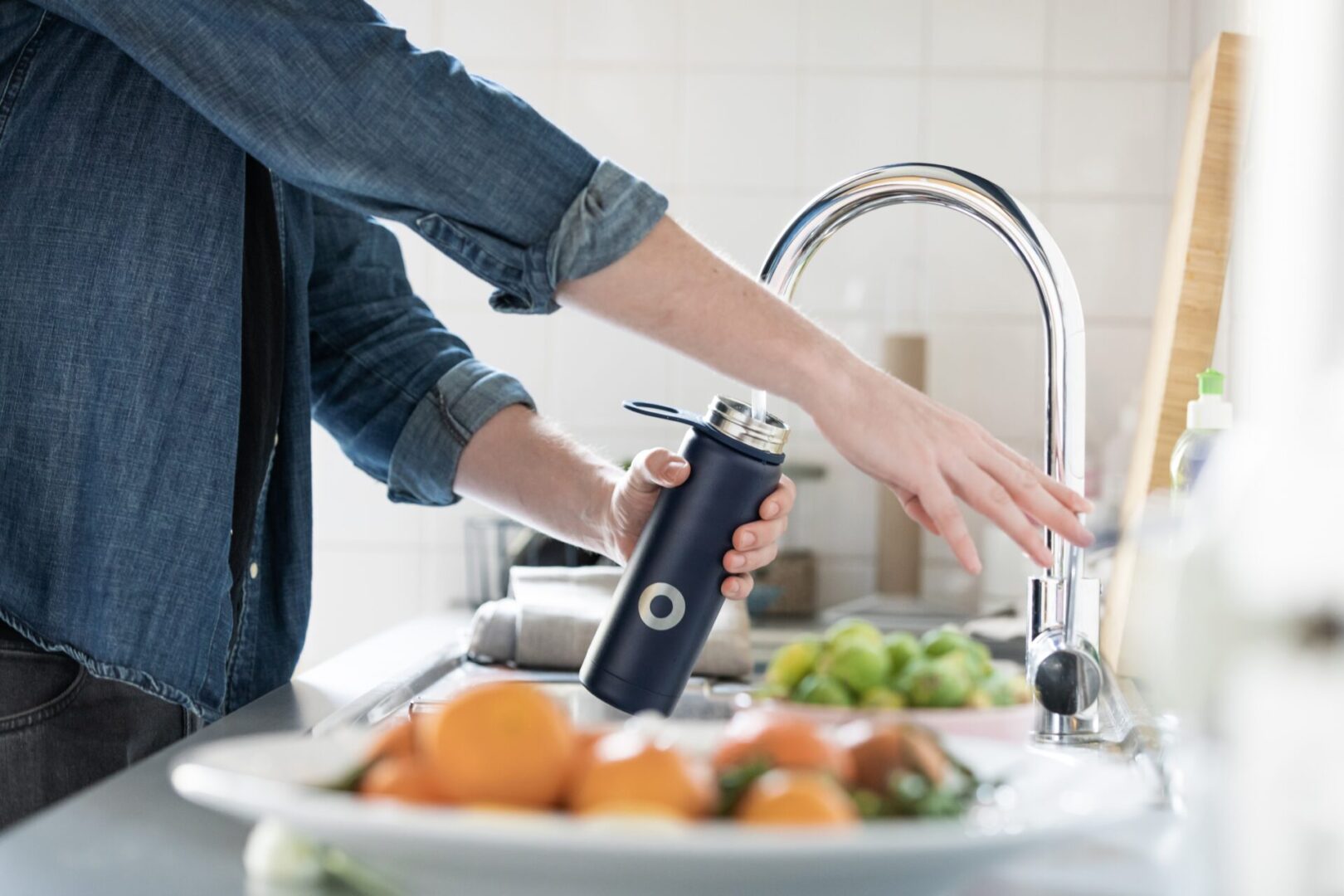 A person is using an electric juicer in the kitchen.